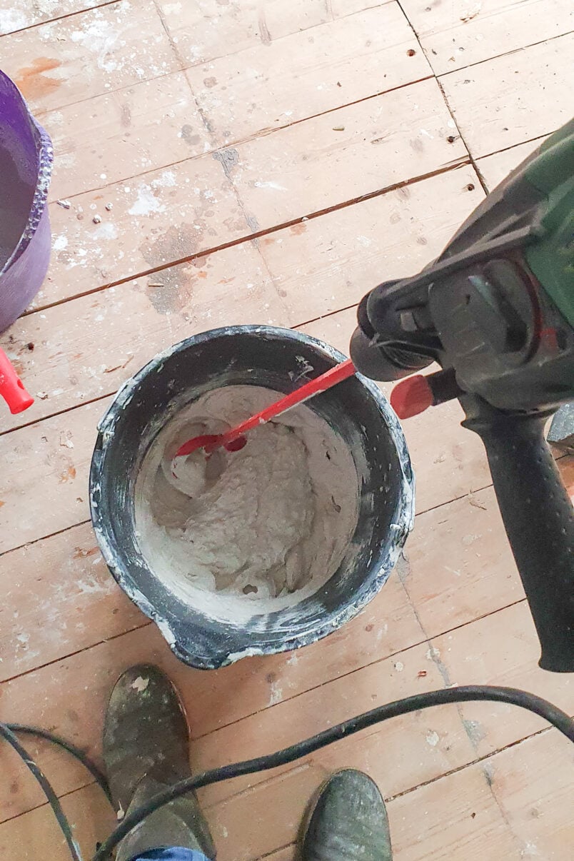 mixing plaster in bucket with drill and attachment